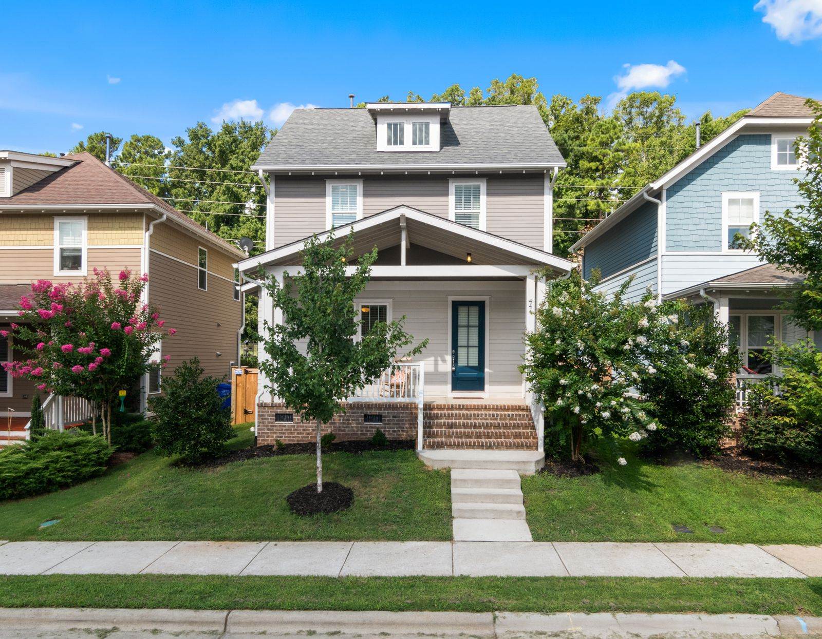 A beautiful suburban home with a well-maintained lawn and vibrant surroundings